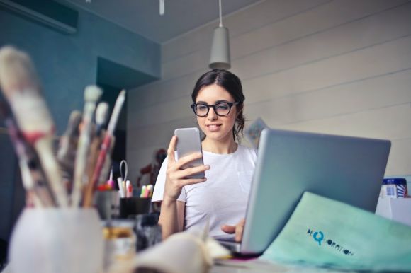 Online Business - woman in white shirt using smartphone