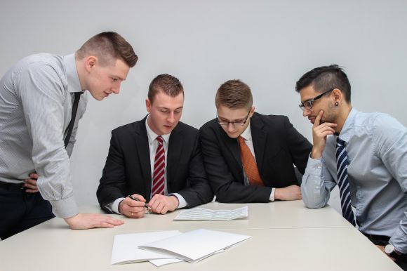 Business Management - four men looking to the paper on table