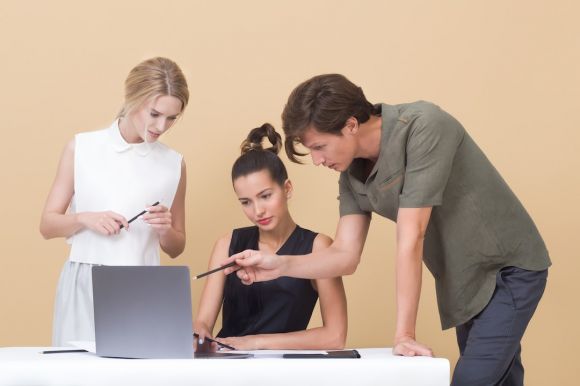 Online Business - man teaching woman while pointing on gray laptop