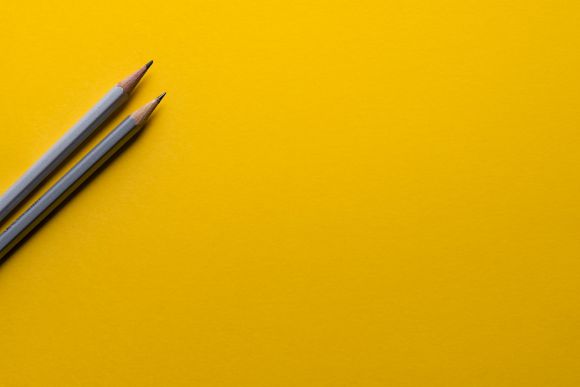 Entrepreneurship - two gray pencils on yellow surface