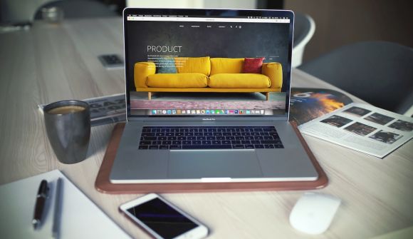 Online Business - turned on MacBook Pro beside gray mug