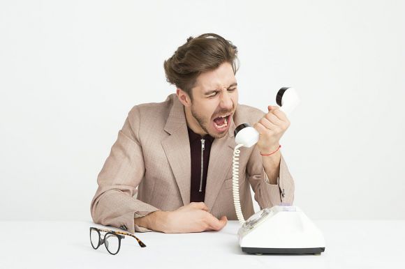 Customer Service - man holding telephone screaming