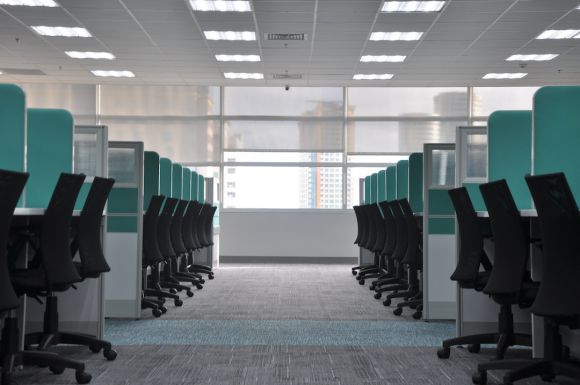 Employees - empty black rolling chairs at cubicles