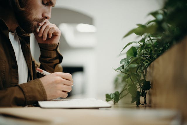 homme avec un stylo et un cahier
